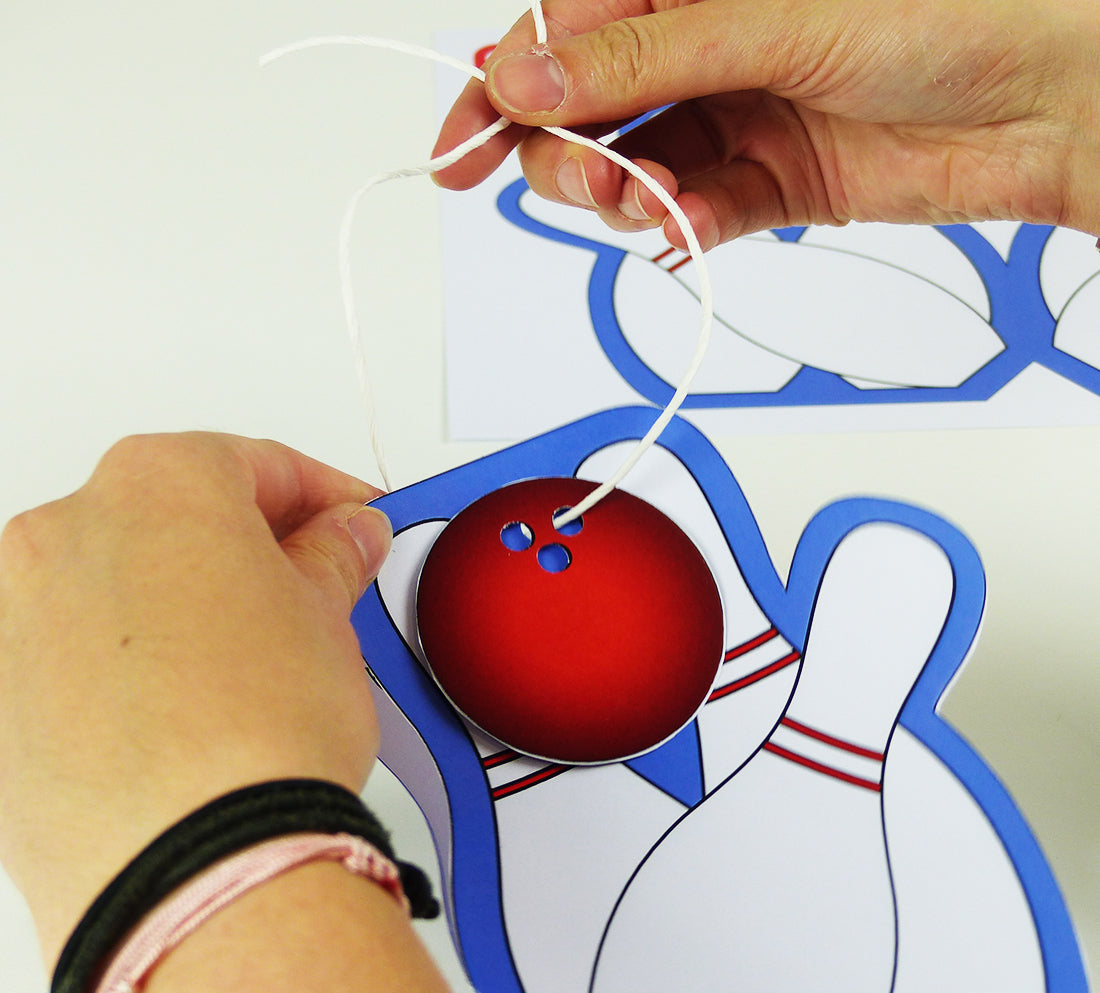 Zum Abschluss kann eine ausgedruckte Bowlingkugel mittels einem Faden an der balloonas Bowling Einladungskarte befestigt werden.
